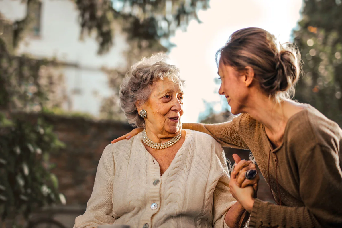 Smiling senior woman holding hands with a caregiver in Palm Beach County, FL